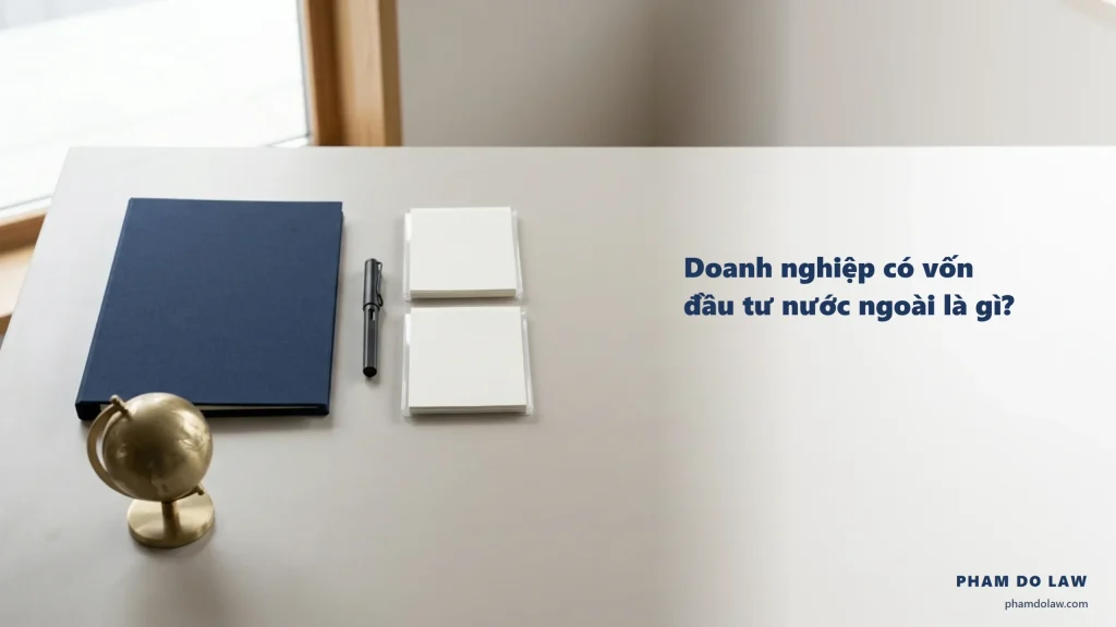Doanh nghiệp có vốn đầu tư nước ngoài là gì: bìa hồ sơ navy, quả địa cầu đồng, bút và hai tệp tài liệu trên bàn làm việc