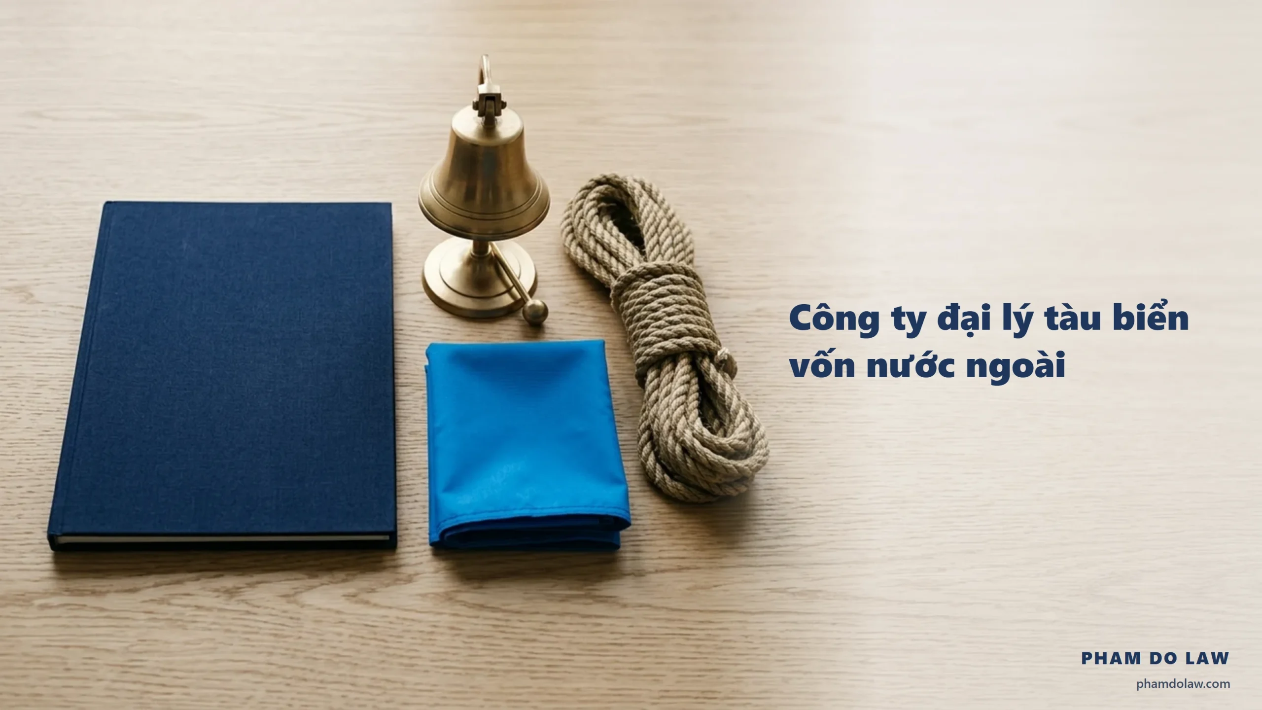 Thành lập công ty đại lý tàu biển vốn nước ngoài: bìa hồ sơ navy, chuông tàu, cuộn dây neo và cờ hiệu xanh trên bàn